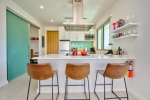 a kitchen with a large white island with two bar stools at Luxury Condo at Harbour Walk in Red Bay Estate