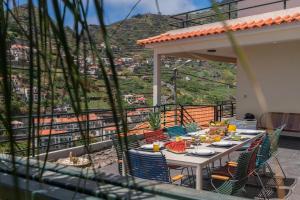 a table on a balcony with a view of a mountain at Casa das Maravilhas by An Island Apart in Câmara de Lobos