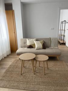 ein Wohnzimmer mit einer Couch und zwei Tischen in der Unterkunft Apartamento acogedor en el centro de Cangas in Cangas