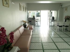 sala de estar con sofá, mesas y sillas en Chomdao Hotel, en Rayong
