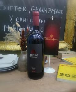ピロトにあるHotel style rooms & restaurant Pirocanacのグラスの横に置かれたワイン1本
