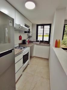 Una cocina con gabinetes blancos y un horno de estufa. en Departamento entero Mirador de Jujuy, en San Salvador de Jujuy