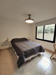 Un dormitorio con una cama en una habitación con ventana. en Departamento entero Mirador de Jujuy, en San Salvador de Jujuy 6 fotos más