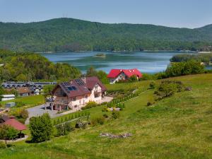 uma vista aérea de uma casa numa colina com um lago em Willa Diana- z panoramą jeziora i gór w Polańczyku em Polańczyk