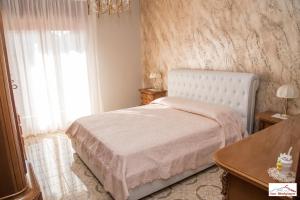 a bedroom with a white bed and a window at Casa Montegrappa - tra Etna e Mare Parcheggio gratuito in Zafferana Etnea