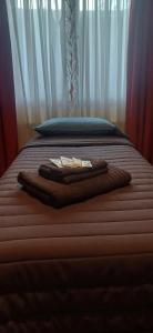 a bed with two towels on top of it at Casa céntrica compartida in Ushuaia