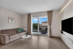 a living room with a couch and a large window at Villa Olea Prestige in Promajna