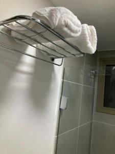 a white towel on a rack in a bathroom at Via Première - Flat - Riocentro - Barra Olímpica - Vista Montanha in Rio de Janeiro