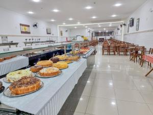 a bakery with several tables with different types of cakes at Hotel Santo Afonso in Aparecida +16 photos