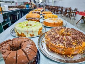 a table topped with different types of cakes on plates at Hotel Santo Afonso in Aparecida