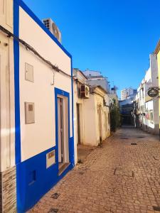 Un callejón vacío con un edificio azul y blanco. en Maison M, en Portimão