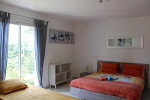 Schlafzimmer mit einem Bett mit roten Kissen und einem Fenster in der Unterkunft Résidence Peylon in Flayosc