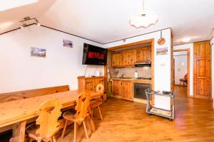 una cucina con tavolo in legno e sedie in legno di Mara's House - Piste da Sci e Garage privato a Sauze d'Oulx Altre 12 foto