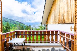 un balcone con tavolo e vista sulle montagne di Mara's House - Piste da Sci e Garage privato a Sauze d'Oulx