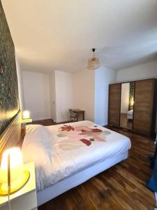 a bedroom with a white bed with flowers on it at Joli appartement en centre-ville in Chalon-sur-Saône