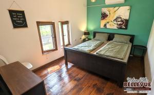 um quarto com uma cama grande e piso em madeira em Arode Nature Villa Bellevue em Katselovo