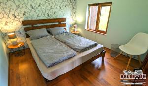 1 dormitorio con 1 cama con silla y ventana en Arode Nature Villa Bellevue, en Katselovo 70 fotos más