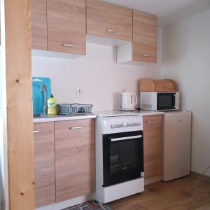 a kitchen with a stove and a microwave at Sielanka na wzgórzu in Czostków