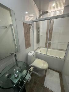 a bathroom with a glass sink and a toilet at Hotel Real De Minas in El Paso
