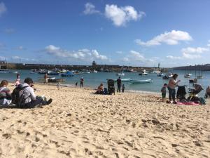 un grupo de personas en una playa con barcos en el agua en Penny's Place, en Carbis Bay 7 fotos más