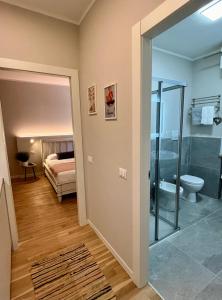 a bathroom with a toilet and a bedroom with a bed at Garda Flow Holiday Home in Lonato del Garda