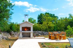 a fireplace in a yard with a table and a bench at Villa Lea&Robi in Unešić