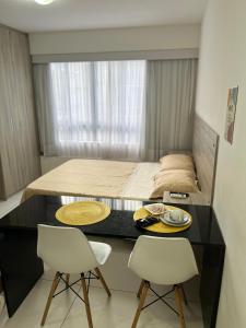 una camera con un letto e una scrivania con due sedie di Golden Point Apartamento em Recife a Recife