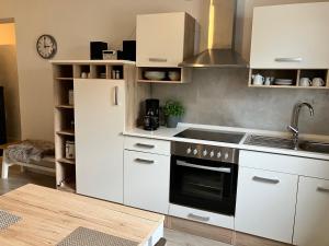 Una cocina con gabinetes blancos y un horno de estufa. en Ferienwohnung Augenblicke, en Olsberg