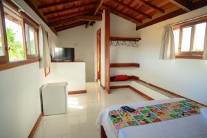 a bedroom with a bed and a television in it at Pousada Flor do Arraial in Arraial d'Ajuda