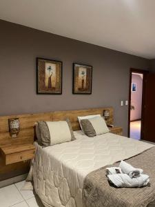 a bedroom with a large bed with two towels on it at Serra Negra Pousada Spa in Guarapari