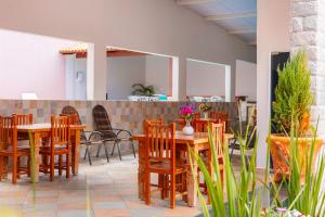 une salle à manger avec des tables et des chaises en bois dans l'établissement Pousada Meia Lua, à Pirenópolis