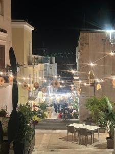 a patio with a table and chairs at night at B&B Tor Di Lupo in Mattinata