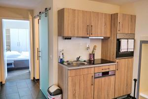 a kitchen with wooden cabinets and a sink at Resort Deichgraf Resort Deichgraf 31-12 in Wremen
