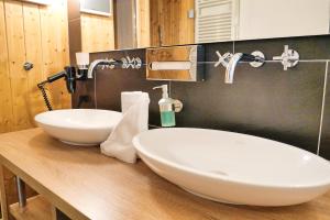 a bathroom with two white sinks on a wooden counter at Resort Deichgraf Resort Deichgraf 31-12 in Wremen