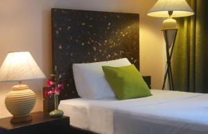 a bedroom with a bed with a green pillow and a lamp at PapaCrab Boutique Guesthouse in Kamala Beach +15 photos