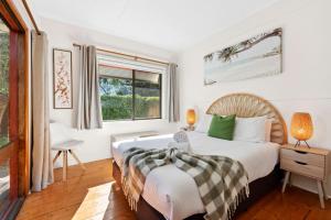 a bedroom with a bed and a window at Park Cottage Barwon Heads in Barwon Heads