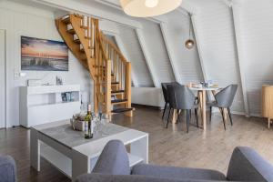 a living room with a table and chairs and a staircase at 50099Deichnest in Carolinensiel