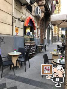 a patio with tables and chairs and a restaurant at Suite Ottocento napoletano in Naples