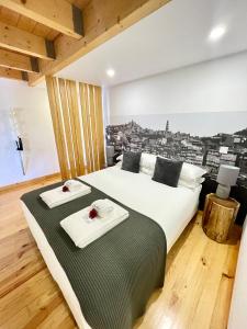 a bedroom with a bed with two towels on it at 1118 Lofts in Porto
