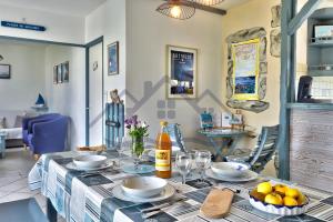 a dining room with a table with a bottle of wine at LocaLise - M3B - Souvenir du Guil - Maison de plain-pied avec jardin clos au Guilvinec - Tout à pied, plages, port, centre, commerces, marché - Wif inclus - Linge de lit inclus - Animaux bienvenus in Le Guilvinec