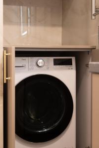 a white washer and dryer in a kitchen at VIXI Skylum in Vilnius +21 photos