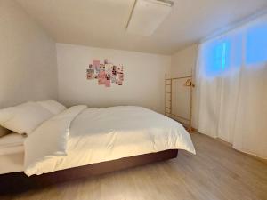 sypialnia z białym łóżkiem i oknem w obiekcie H Stay w mieście Inczon