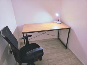 a desk with a chair and a desk with a lamp at H Stay in Incheon