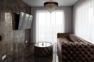 a living room with a leather couch and a table at VIXI Skylum in Vilnius