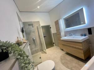 a bathroom with a sink and a shower at Modernes Haus mit Wintergarten in Immenhausen