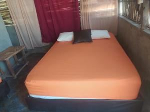 Cette chambre comprend un grand lit orange et une chaise. dans l'établissement Alojamiento Eco Tours Kaigee, à Mayapo