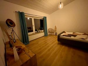 a bedroom with a bed and a wooden floor at Modernes Haus mit Wintergarten in Immenhausen