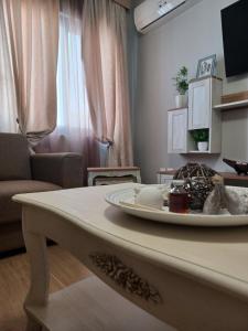Melenia Suites في بلدة رودس: غرفة معيشة مع طاولة عليها لوحة
