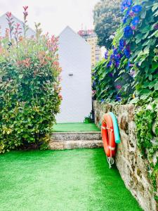 a garden with a house and a surfboard on the grass at 1118 Lofts in Porto