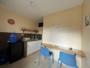 a kitchen with two blue chairs and a counter at Mini Apartment with terrace in Baños